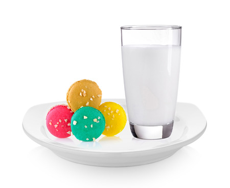 milk and macaroons in white plate on white backgroundの写真素材