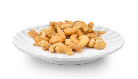 Cashews  in plate on white backgroundの写真素材