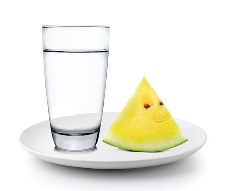 Glass of water and watermelon in a plate isolated on a white backgroundの写真素材
