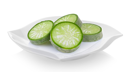 slice green radish in a plate on white backgroundの写真素材