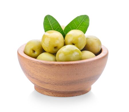 green olives in wood bowl on a white backgroundの写真素材