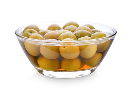 green olives in a bowl on white backgroundの写真素材