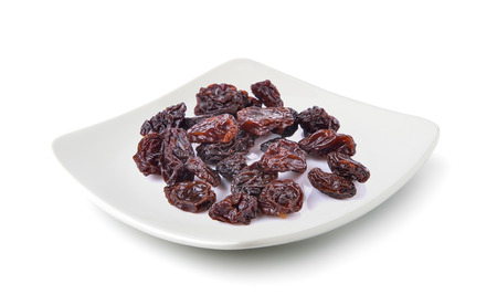 Dried raisins in a plate isolated on white backgroundの写真素材
