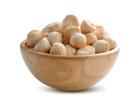 Khanom Ping (a type of traditional Thai dessert consisting of many small, often brightly coloured, cookies made from flour and coconut) in wood bowl on white backgroundの写真素材