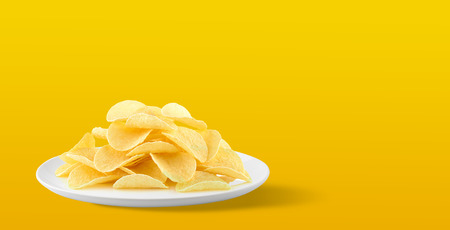 Potato chips in a plate on yellow background. with Copy space for your text.の写真素材