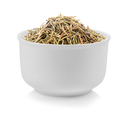 Dried rosemary leaves in a bowl on white backgroundの写真素材