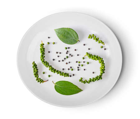 black peppers in a plate on white backgroundの写真素材