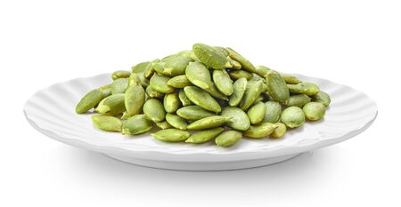 Pumpkin seeds in white plate on white backgroundの写真素材