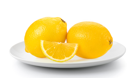 Lemon and cut half slice in plate isolated on a white backgroundの写真素材