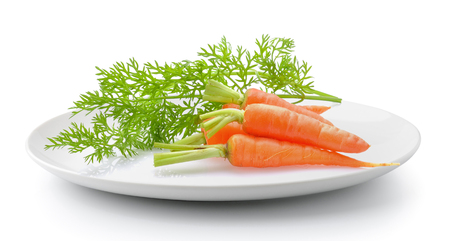 Carrot vegetable with leaves in plate isolated on a white backgroundの写真素材