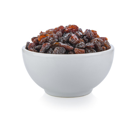 Black raisin on white bowl isolated on white backgroundの写真素材