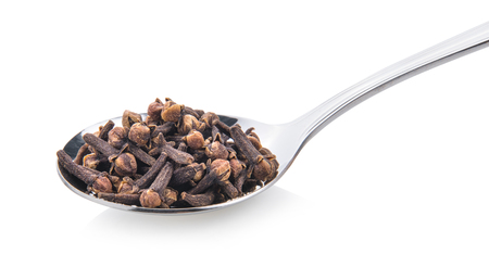 cloves spices in spoon on white backgroundの写真素材