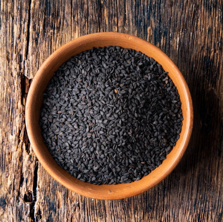 sesame seeds in a ceramic bowl on woodenの写真素材