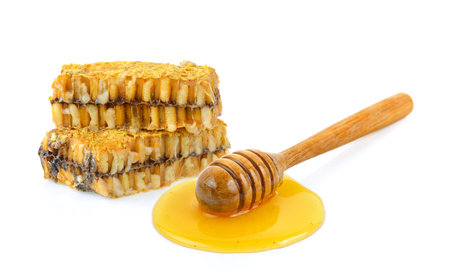 Wooden honey dipper with honey isolated on white backgroundの写真素材