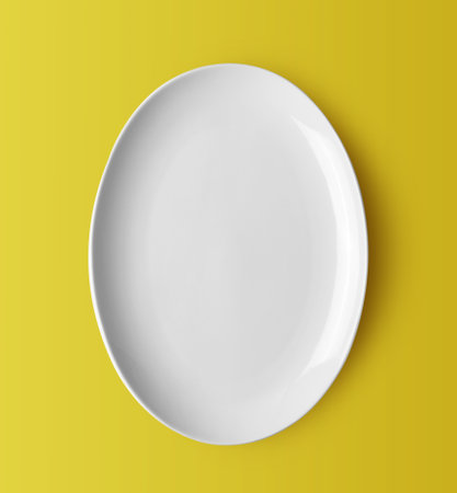 white ceramic plate on yellow backgroundの写真素材