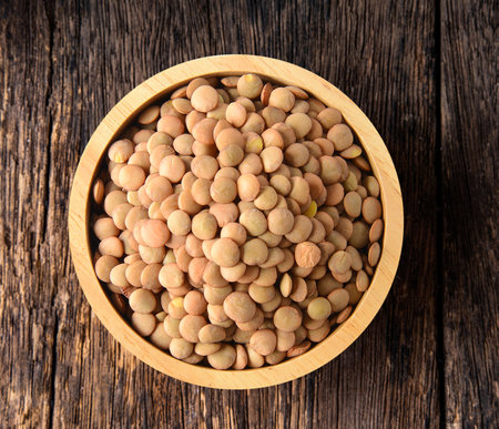 lentils in wood bowl on wood tableの写真素材