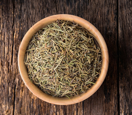 Dried rosemary leaves in wooden bowlの写真素材