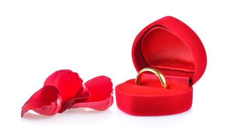 red box gold ring and rose petals on white backgroundの写真素材