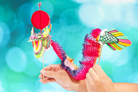 Paper dragon puppet isolated on blueの写真素材