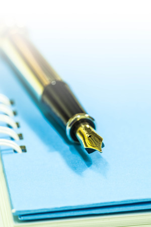 Gold fountain pen on notebookの写真素材