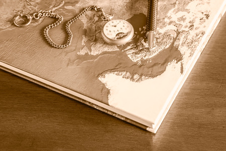 Map book, pens, pocket watch on wood tableの写真素材