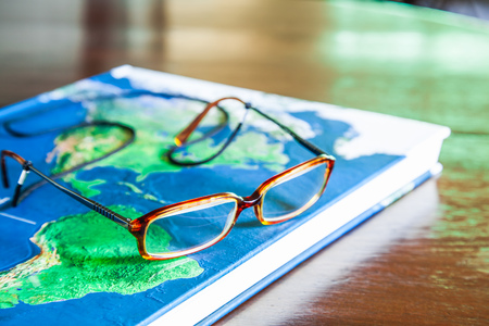 Map book and glasses on wood tableの写真素材