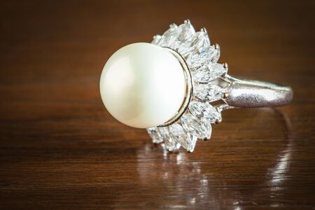Beautiful pearl ring on wood tableの写真素材