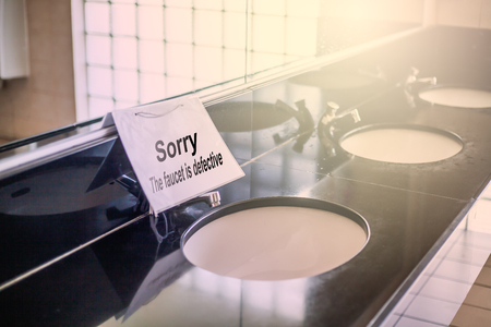 Labels identify malfunctioning faucets in the bathroomの写真素材