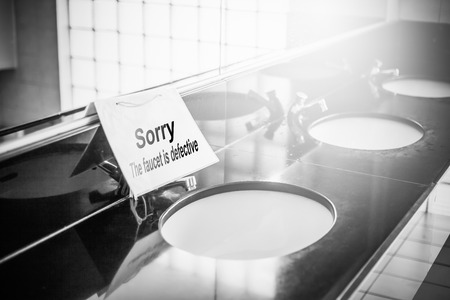 Labels identify malfunctioning faucets in the bathroomの写真素材