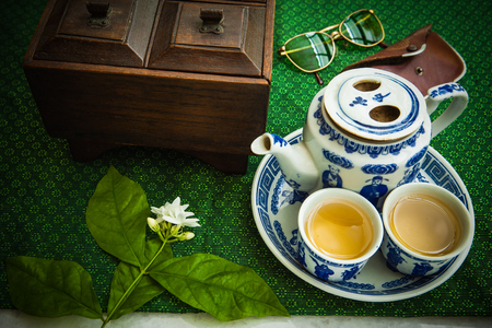 Chinese tea with glasses, books and wooden boxes on the tableの写真素材