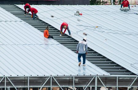 Workers roofing metal for the roof on a large commercial building at Petchkasem road Omnoi, Krathum Baen, Samut Sakhon, Thailand, May 25, 2019のeditorial素材