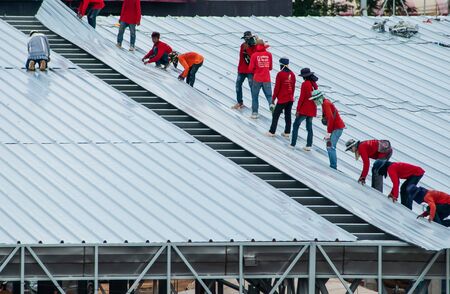 Workers roofing metal for the roof on a large commercial building at Petchkasem road Omnoi, Krathum Baen, Samut Sakhon, Thailand, May 25, 2019のeditorial素材