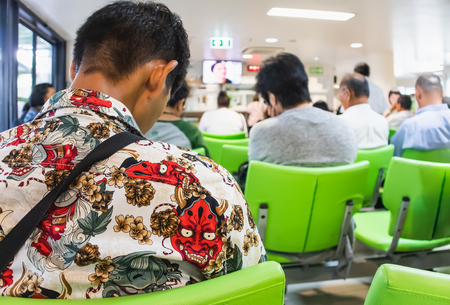 People sitting on chairs waiting in queue to wait for treatment from doctors in the Kluaynamthai Hospital at Rama 4 road Bangkok Thailand,  March 13, 2019のeditorial素材