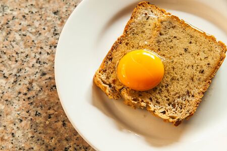 Raw eggs and Whole wheat bread on white plate