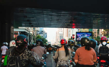 Motorcycles are waiting for a green light under the elevated bridge at Sathorn Road Bangkok Thailand, February 21, 2020のeditorial素材