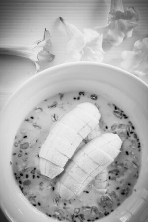 Cereal in soy milk with banana in white bowl, Breakfast backgroundの写真素材