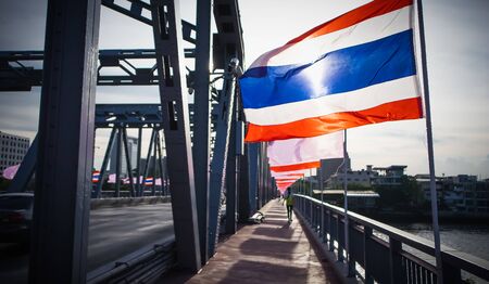Thai national flag waving in the wind on Krung Thonburi Bridge at Rajvithi Road Bangkok Thailand, 15 Juneの写真素材