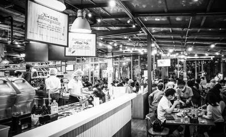 Thai people eating and drinking in Thai restaurant in the evening at Soi Lasalle Sukhumvit road...