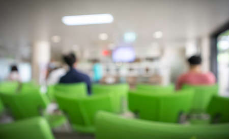 Blurred, People sitting on green chairs waiting in queue to wait for treatment from doctors in the...