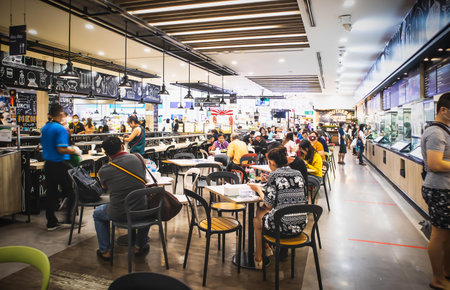 People eating and drinking in food court in Shopping Mall at Sukhumvit road Bangjak Prakanong Bangkok Thailand, July 4, 2020