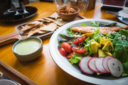 Salmon salad with appetizer on the table in restaurant Bangkok