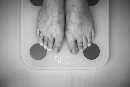 Man weighing on digital scale, Backgroundsの写真素材