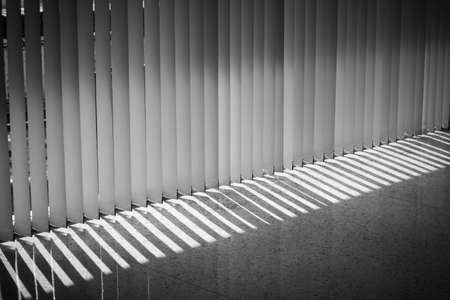 Windows with vertical blinds, Detail of the interior texture with lights and shadows on the floor, The concept backgroundの写真素材