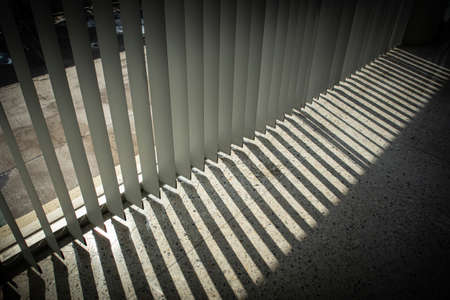 Windows with vertical blinds, Detail of the interior texture with lights and shadows on the floor, The concept backgroundの写真素材