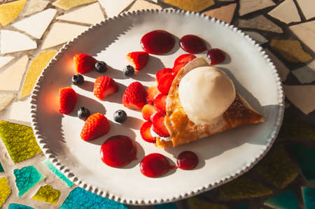 Vanilla ice cream on strawberry pie and blueberry on white plateの写真素材