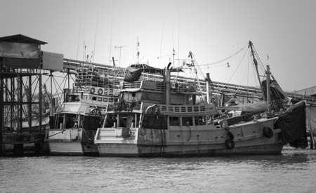Fishing boats moored at the pier on the Chao Phraya river in Samut Prakan, Thailandの写真素材