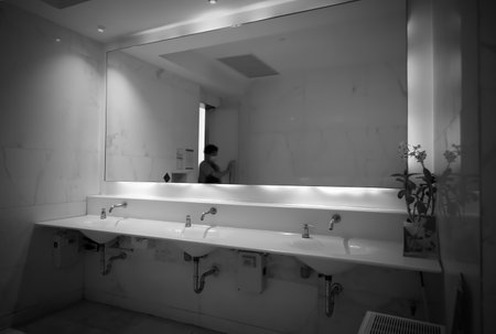 A man opens the door to the men's restroom in a shopping mall, Bangkok, Thailandの写真素材