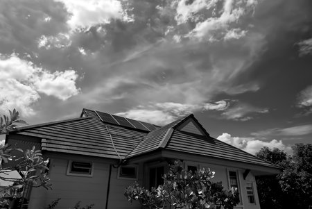 Solar panels on the roof of the house with clouds and sky in natural light, Natural lightの写真素材