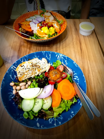 Chicken salad in a bowl on the table in a restaurantの写真素材