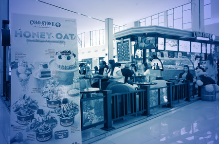 August 12, 2023, Signs display food items in front of ice cream and bakery shops and customers eat and drink inside the shop in a department store on Bangna-trad road Bangkokのeditorial素材